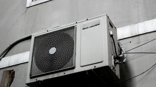 Outdoor unit of air conditioner on the wall of the building with wires